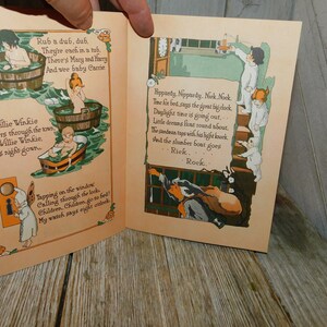 Op de afbeelding: Een open vintage kinderboek met illustraties van kinderen in badkuipen en een klok. De tekst luidt "Rub a dub, dub. They're each in a tub. There's Mary and Harry And wee baby Carrie" en "Hippardy, Neppardy. Nek, Nook, Time for bed, says the great big clock, Daylight time is going out... Little dreams float round about. The panduan taps with his light knock And the slumber boat goes Riek. Rook."