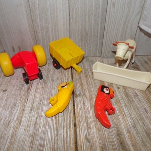 May include: A set of vintage plastic farm toys, including a red tractor, a yellow wagon, a white cow, and two colorful parrots. The toys are made of durable plastic and are perfect for imaginative play.