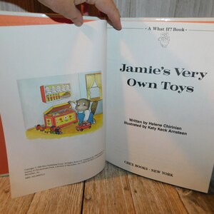 May include: A children's book titled "Jamie's Very Own Toys" by Helene Chirinian, illustrated by Katy Keck Arnsteen. The cover features a cartoon illustration of a bear opening a toy chest.
