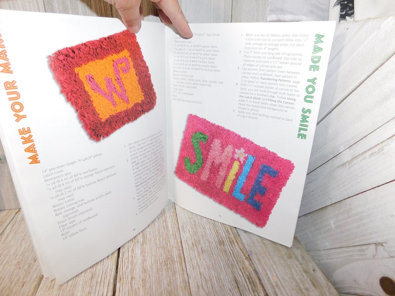 May include: A book titled "Make Your Own" with the words "Made You Smile" on the cover. The book features instructions for creating latch hook rugs. The book shows two examples of latch hook rugs, one with the letters "WP" and the other with the word "SMILE".