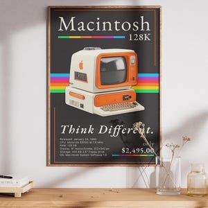 Könnte beinhalten: Ein gerahmtes Poster mit einem Vintage-Computer Macintosh 128K in Creme und Orange. Das Design umfasst einen Regenbogenstreifen, den Text Macintosh 128K, Think Different und technische Daten auf schwarzem Hintergrund in weißer Serifenschrift.