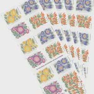 May include: A collection of postage stamps arranged in overlapping rows, featuring colorful botanical illustrations of yellow, orange, purple, and pink flowers on a white background, with each stamp showing distinct floral patterns and text.