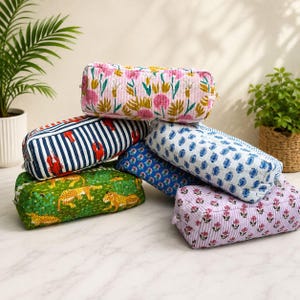 May include: A collection of six rectangular quilted pouches featuring various patterns including pink floral, blue and white stripes with red lobster motifs, green with yellow leopards, blue paisley, and light purple with small floral prints.