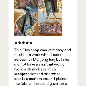 May include: A quilted fabric tote bag featuring a floral pattern with pink flowers and green leaves on a white background. The interior is lined with a green and white striped fabric and includes a pocket. The bag has two long shoulder straps.