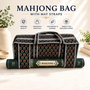May include: A black rectangular mahjong bag with a repeating floral pattern in orange and green, featuring white and black striped trim and handles. A dark green rolled mahjong mat is secured underneath with straps, labelled 33 INCH on both ends.