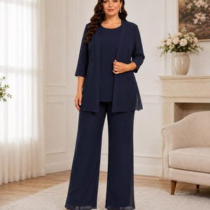 May include: A navy blue three-piece ensemble consisting of a sleeveless scoop-neck top, a matching open-front jacket with three-quarter length sleeves, and wide-leg trousers. The outfit is crafted from a solid-colored, lightweight fabric.