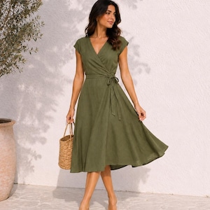 Può includere: Un abito a portafoglio midi color verde oliva con maniche corte, scollo a V e cintura in tessuto abbinata in vita. Il capo presenta una gonna svasata che arriva sotto le ginocchia ed è realizzato in un tessuto di colore solido.
