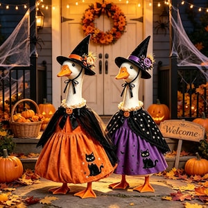 May include: Two white geese dressed in Halloween costumes. One wears an orange dress with a black cat print and a black witch hat. The other wears a purple dress with a black cat print and a black witch hat. Both have black capes and orange beaks.