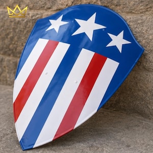 May include: A heater-style shield featuring a glossy finish with a blue upper section adorned with three white five-pointed stars. The lower portion displays vertical stripes in alternating red, white, and blue colours, creating a patriotic design.
