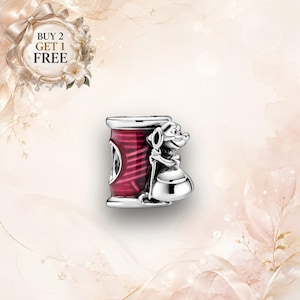 May include: A silver charm bead featuring a cylindrical spool of dark red thread with a sculpted silver mouse character standing beside it, holding a needle. The charm has a polished metallic finish and intricate detailing on the mouse figure.