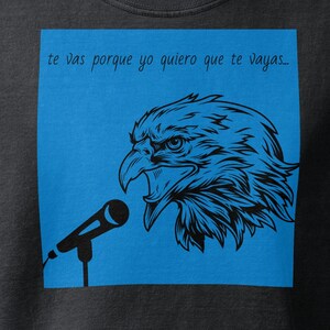 May include: A black cropped t-shirt featuring a blue square graphic on the front. The graphic displays a black line-art illustration of an eagle head facing a microphone with the text "te vas porque yo quiero que te vayas..." above it.