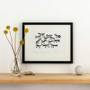 Puede incluir: Impresión en blanco y negro de un grupo de pájaros con el título "Wagtails" en un marco negro sobre una pared blanca.