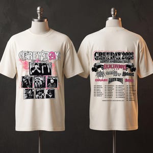 Puede incluir: Una camiseta de manga corta color hueso con un estampado gráfico en la parte delantera y trasera. El frente muestra el texto GREY DAY 2026 con fotos en blanco y negro. La parte posterior presenta el texto GREY DAY 2026 NORTH AMERICAN TOUR con una lista de ciudades.