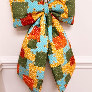 Colgador de puerta con lazo de patchwork otoñal
