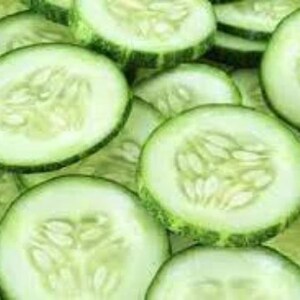 May include: Close-up of thinly sliced green cucumbers. The cucumber slices are arranged in a random pattern, showing the light green flesh and dark green skin.
