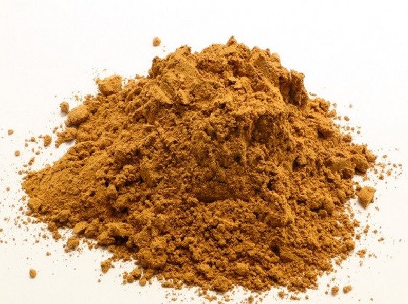 May include: A pile of loose, brown, ground cinnamon powder on a white background.