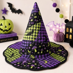May include: A quilted witch hat featuring a patchwork design of purple and lime green gingham squares alternating with black fabric panels. The black sections are decorated with lime green and purple prints of bats, mushrooms, stars, and moons.