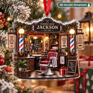 Könnte beinhalten: Ein 3D-Acryl-Ornament mit einem detaillierten Friseursalon-Interieur, rotem Stuhl, Schachbrettboden und zwei Barber-Stangen. Das Schild zeigt BARBER SHOP JACKSON EST. 2026, ergänzt durch Texte wie GOOD HAIR BETTER MOOD und CUT SHAVE STYLE REPEAT.