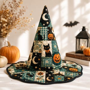 May include: A quilted witch hat featuring a patchwork design with black cats, orange jack-o'-lanterns, crescent moons, and stars. The fabric displays a color palette of dark teal, black, and orange with a scalloped brim and stitched details.