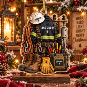 May include: A personalized line crew ornament featuring a white hard hat with the name Mason, a dark jacket with the text LINE CREW, brown work boots, a tool belt, a tool bag with the name Mason, and yellow gloves with a lightning bolt icon.