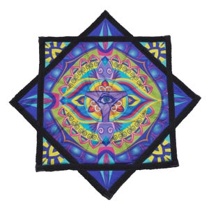 May include: A star-shaped fabric mat featuring a vibrant, multi-coloured mandala pattern with shades of blue, green, yellow, and pink. The centre displays a detailed eye graphic surrounded by intricate geometric shapes and black stitched borders.