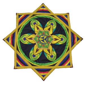 Könnte beinhalten: Ein sternförmiger Wandbehang aus Stoff mit einem zentralen, mandalaartigen Blumenmuster in Gelb, Grün und Blau auf schwarzem Grund. Die Kanten sind mit gelbem Stoff eingefasst und die äußeren Spitzen zeigen Streifen in Rot, Blau und Gelb.