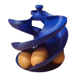 May include: A royal blue plastic egg dispenser featuring a spiral design that allows eggs to roll down from the top to the base. The structure has a central vertical support and a curved track, currently holding three brown chicken eggs at the bottom.