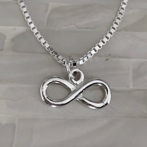 May include: A silver infinity symbol pendant necklace with a box chain.
