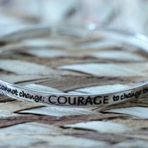 May include: Silver bangle bracelet with the inscription "The things I cannot change; COURAGE to change the things I can."