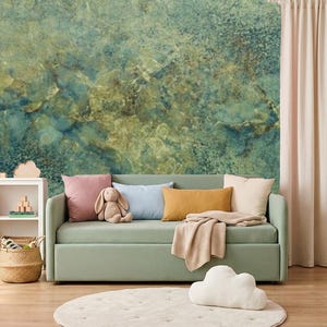 Può includere: Un divano verde chiaro con un cuscino rosa, un cuscino azzurro, un cuscino lombare giallo senape e una coperta beige. Una libreria bianca con libri e giocattoli, un cesto intrecciato e un cuscino da pavimento bianco a forma di nuvola.