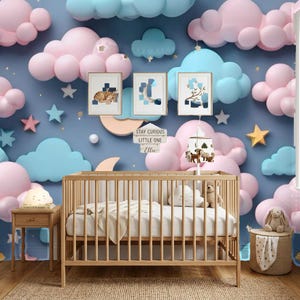 Può includere: Una culla in legno con biancheria bianca davanti a una carta da parati con nuvole e stelle rosa e blu. Tre stampe incorniciate sono appese sopra la culla, insieme a una giostrina e un cartello con la scritta STAY CURIOUS LITTLE ONE Ellie.