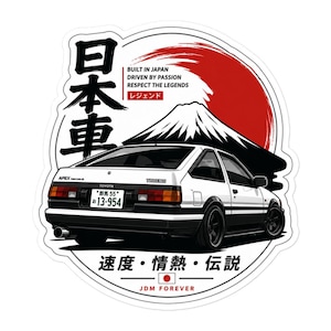Può includere: Un adesivo per auto Toyota Trueno bianco e nero con un sole rosso, il monte Fuji e testo in giapponese. Il design include le frasi BUILT IN JAPAN, DRIVEN BY PASSION, RESPECT THE LEGENDS e JDM FOREVER, insieme a caratteri giapponesi.
