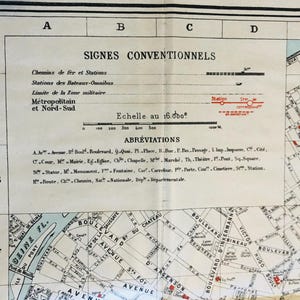 May include: A black and white map of Paris, France, with a scale of 1:16,000. The map shows the Seine River, the Eiffel Tower, and other landmarks. The map also includes a key with symbols for different types of transportation, buildings, and other features.