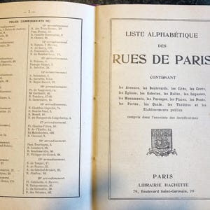 May include: A black and white image of a book with a list of streets in Paris, France. The book is titled "Liste Alphabetique des Rues de Paris" and includes a list of streets, avenues, and other locations in Paris. The book is published by Librairie Hachette.
