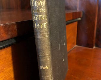May include: An antique book titled "Death and the After Life" with gold lettering on the spine. The book has a dark cover and is positioned on a wooden surface. The author's name, Davis, is also visible.