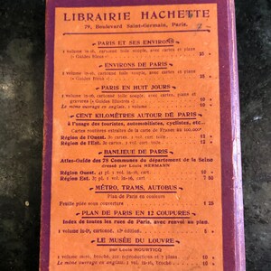 May include: A vintage red and orange book cover with the title "Librairie Hachette" and a list of books and prices in French. The book is about Paris and its surrounding areas.