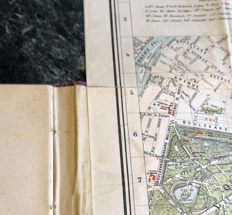 May include: A vintage map of Paris, France, showing the Seine River, the Bois de Boulogne park, and the Avenue de Madrid. The map is divided into sections numbered 3 through 7.