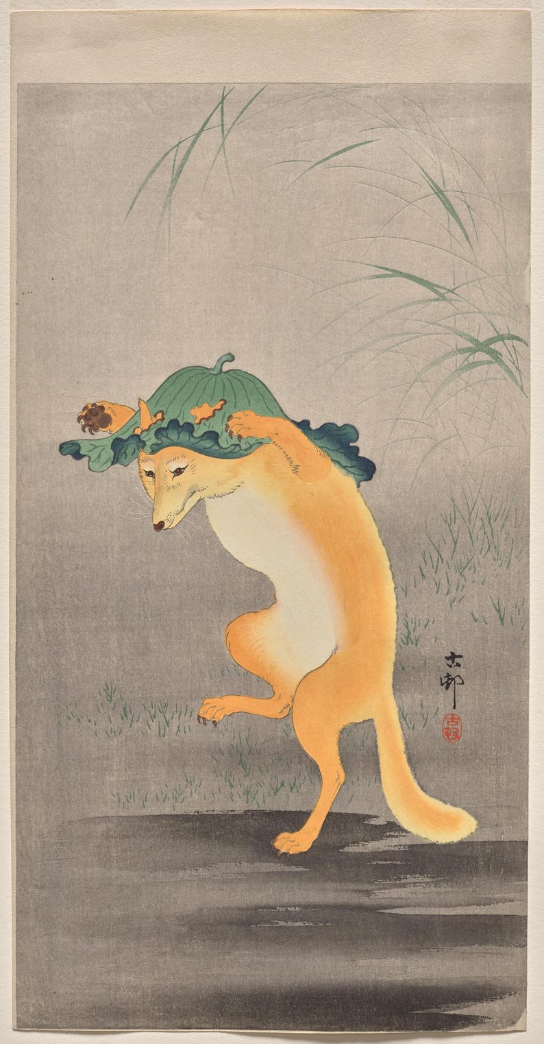 May include: A woodblock print illustration of a golden-orange fox standing on its hind legs. The fox wears a large, green, ruffled leaf as a hat, which it holds with its front paws. The background features faint green grass blades.