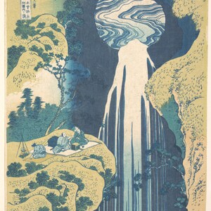 May include: A Japanese woodblock print featuring a tall, stylized waterfall cascading between beige cliffs with dark blue foliage. Three figures sit on a mat on a cliffside ledge, with a small tripod stove nearby. Japanese text appears in the upper left.