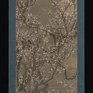 May include: A vertical hanging scroll painting on silk depicting a gnarled plum tree in full bloom with white blossoms against a muted gray background. A pale, circular moon is visible in the upper right. The artwork includes black ink calligraphy and two red seal stamps in the lower right corner.