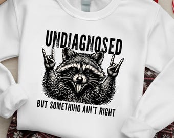 Sin diagnosticar pero algo no está bien PNG, divertido diseño de mapache para sublimación, diseño de camiseta de mapache rockero, descarga digital sarcástica DTF