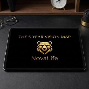 May include: A black tablet screen displaying the gold text THE 5-YEAR VISION MAP above a stylized gold bear head icon and the gold text NovaLife. The tablet is positioned on a dark surface with a pair of glasses, a gold pen, and a black notebook.