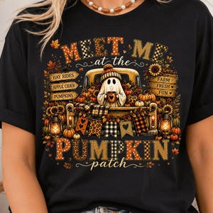 Könnte beinhalten: Ein schwarzes T-Shirt mit einem Grafikdruck eines Geistes, der eine Mütze trägt und eine Tasse auf der Ladefläche eines gelben Lastwagens hält. Der Text lautet MEET ME at the PUMPKIN patch, mit Schildern für HAY RIDES, APPLE CIDER, PUMPKINS, FARM FRESH FUN.