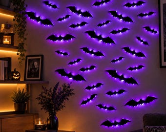 Peut inclure: Une collection d'autocollants muraux en forme de chauve-souris noire disposés en essaim sur un mur. Chaque silhouette de chauve-souris est dotée d'un rétroéclairage LED violet intégré créant un effet de contour lumineux sur le mur.