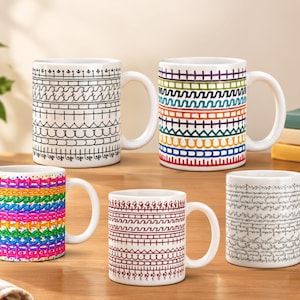 Puede incluir: Cinco tazas de cerámica blanca con asa, cada una con patrones horizontales distintos. Los diseños incluyen arte de líneas negras, rayas multicolores, bandas texturizadas de colores neón, motivos geométricos rojo oscuro y escritura cursiva gris fina.