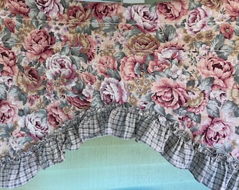 May include: A floral patterned valance with a ruffled edge. The valance is made of a beige fabric with a checkered pattern on the ruffle.