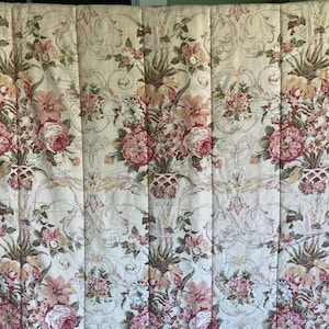 May include: A floral patterned quilt featuring bouquets of pink and red roses, peonies, and other flowers. The flowers are arranged in decorative vases against a cream-colored background with a scrolling design. The quilt is quilted with vertical lines.