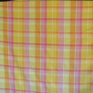May include: Yellow, pink, and orange plaid fabric with a woven texture.