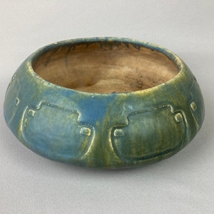 May include: A green and blue ceramic bowl with a geometric design. The bowl is glazed and has a rustic look.