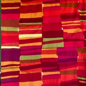 May include: Abstract textile design featuring vertical columns of varying widths and colors. The color palette includes shades of red, orange, yellow, and purple, creating a vibrant and dynamic visual effect. The design is reminiscent of a patchwork or striped pattern.